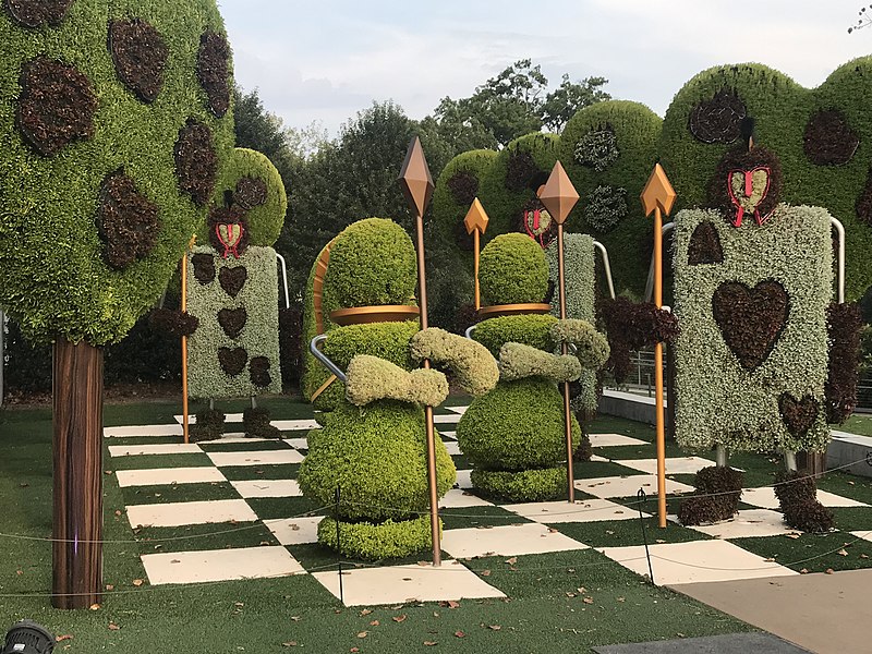 Large topiary on a checkered surface, shaped as guards and playing cards holding spears