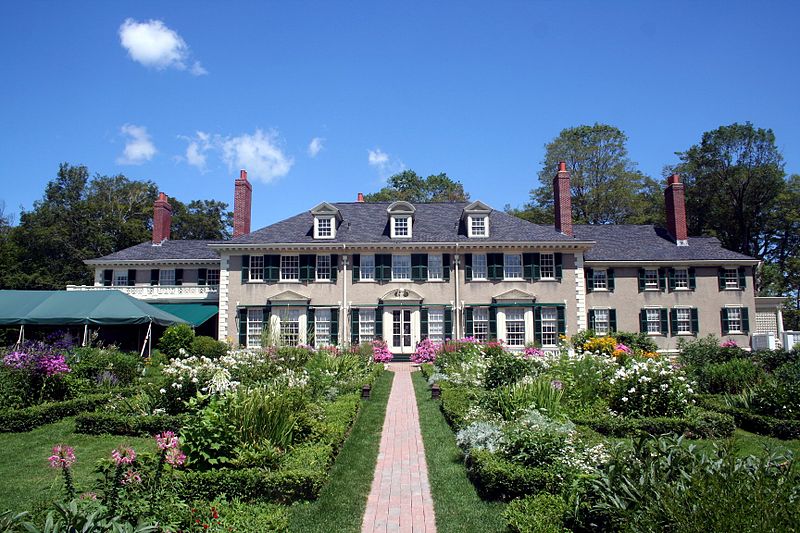 Large mansion with a walkway lined with flowers