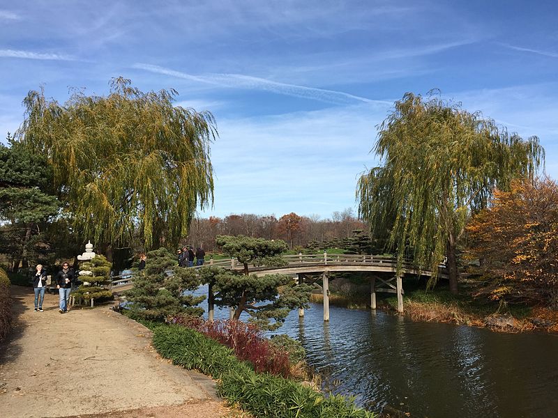 Bridge over a body of water with trees on either end of it.