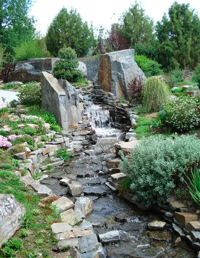 Waterfall moving down uneven rocks surrounded by a rock wall