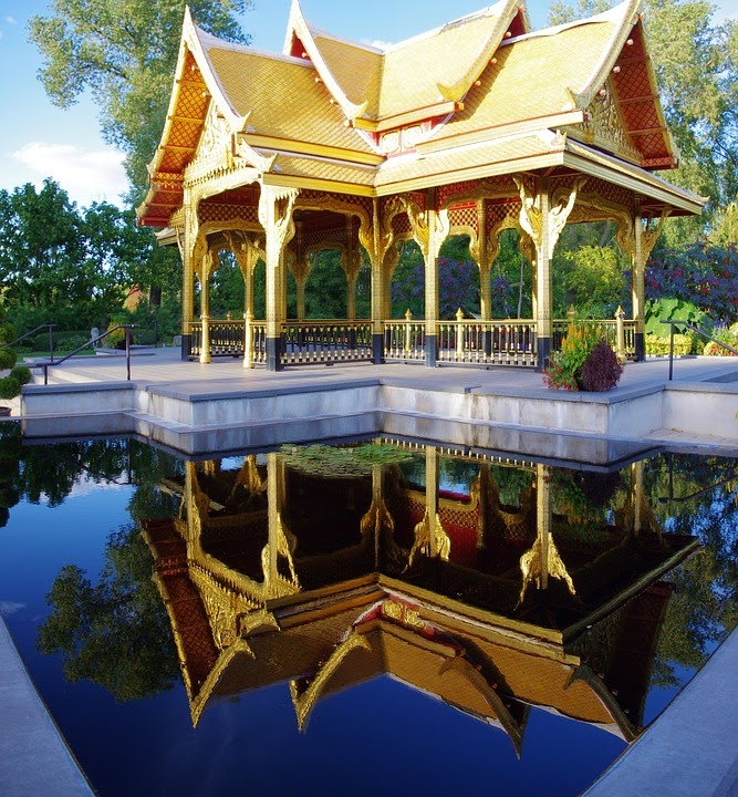 Golden Thai pavilion surrounded by water