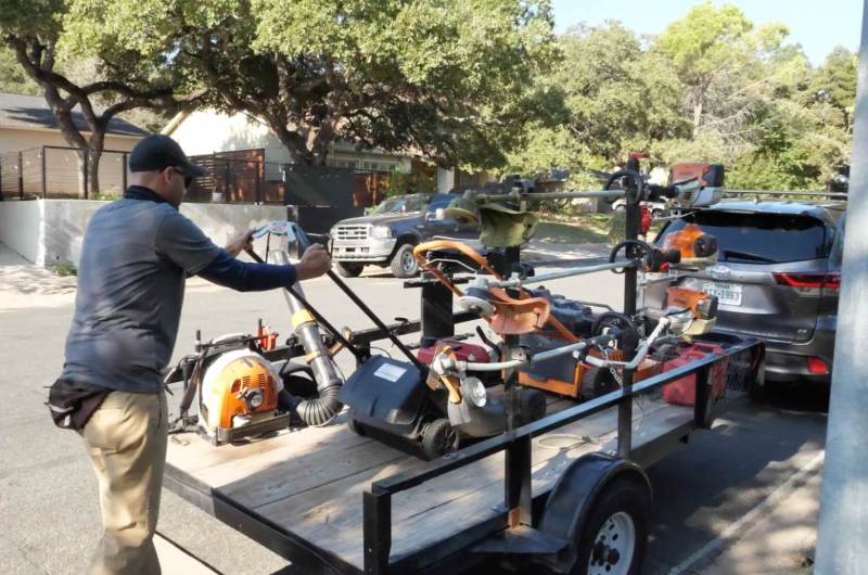 LawnStarter pro Justin Stultz loads lawn care equipment onto a trailer after finishing a residential mowing job in Texas.