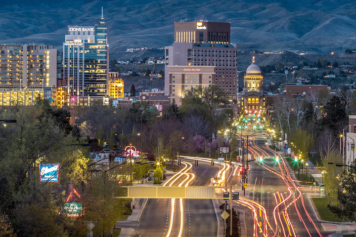 A twilight view of the Boise, Idaho, skyline with the Boise Capitol building and mountains in the background