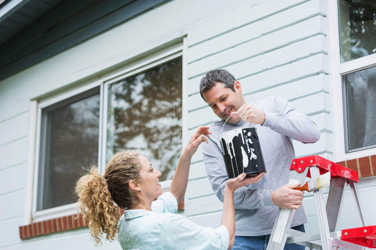 couple painting exterior house