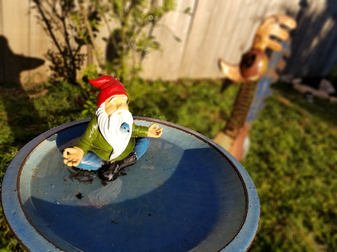 A garden gnome watches over the birdfeeder.