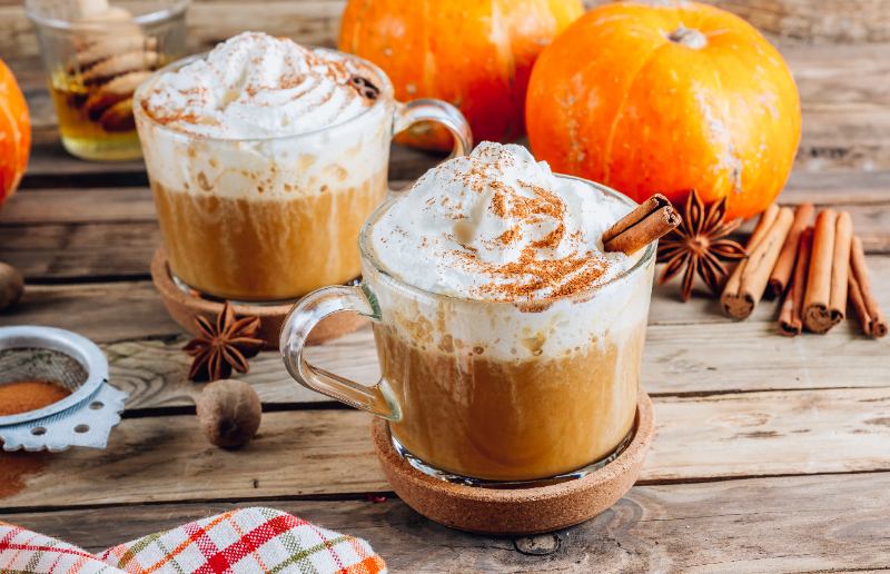Pumpkin spiced latte or coffee in a glass on a vintage table.