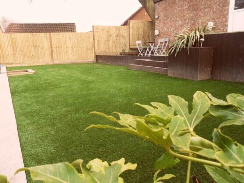 backyard with artificial lawn and patio