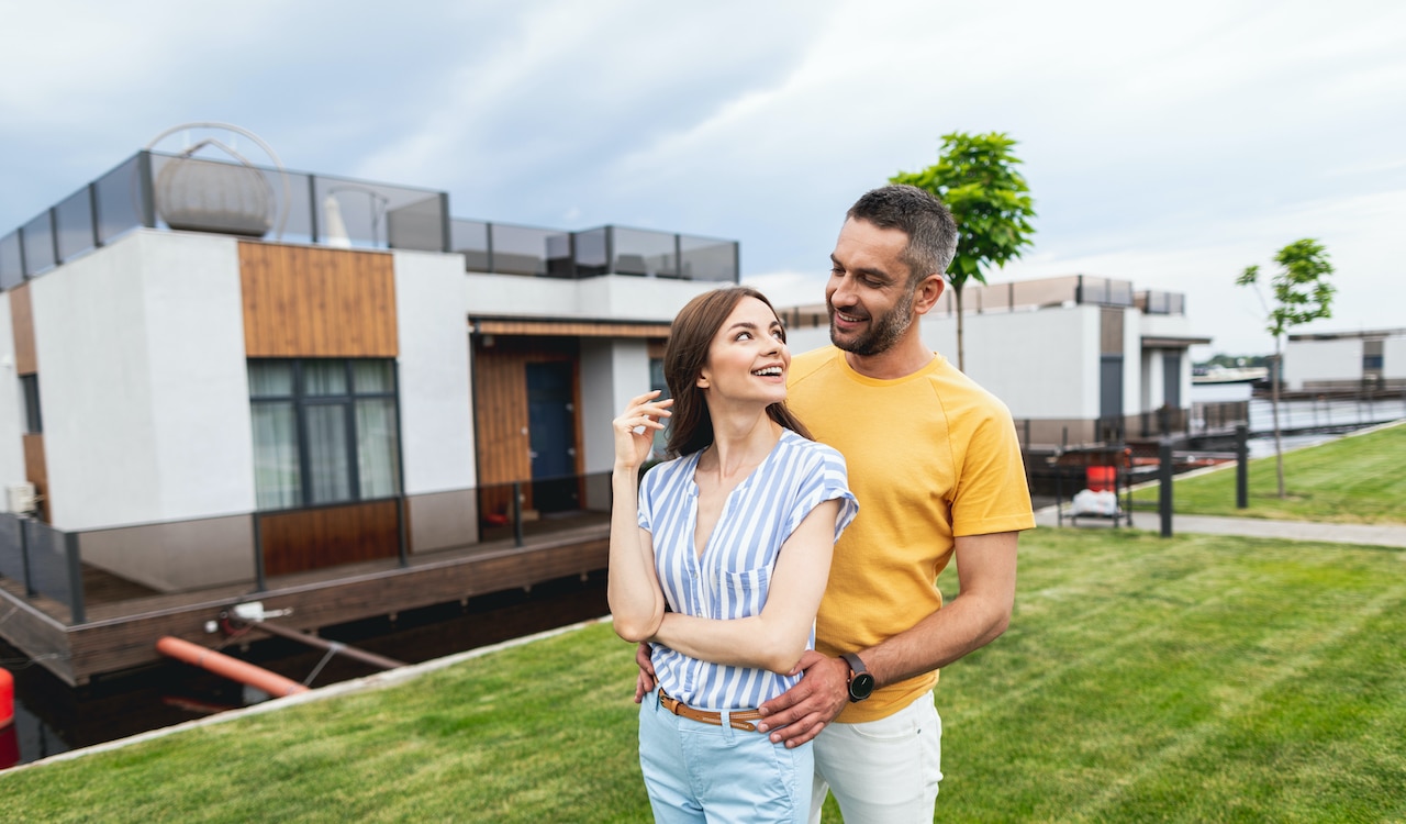couple standing in front of a new house