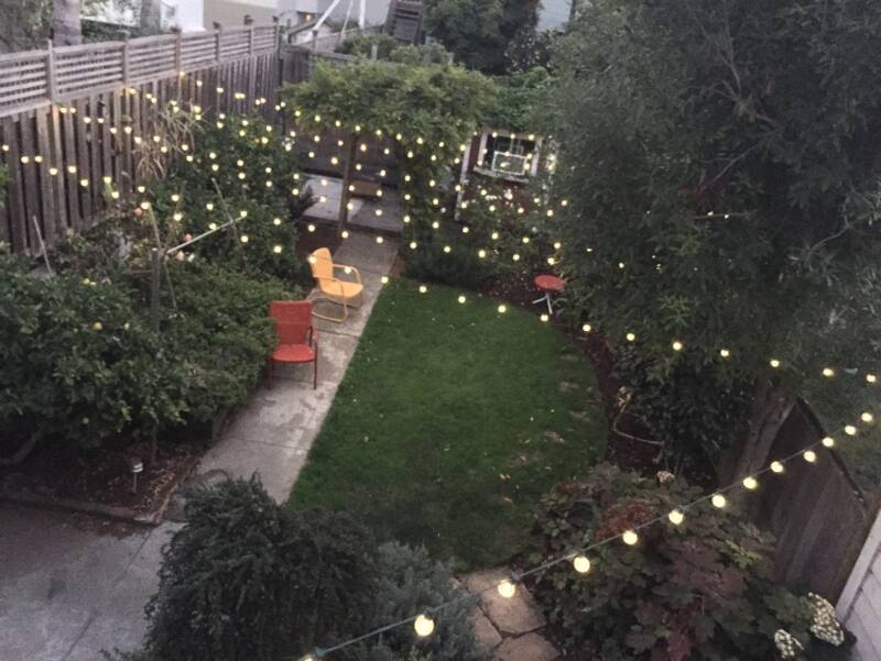string lights over backyard seating area