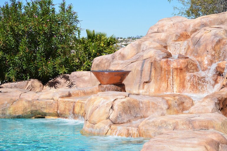 Natural-looking rocks with a fountain feeding into a pool