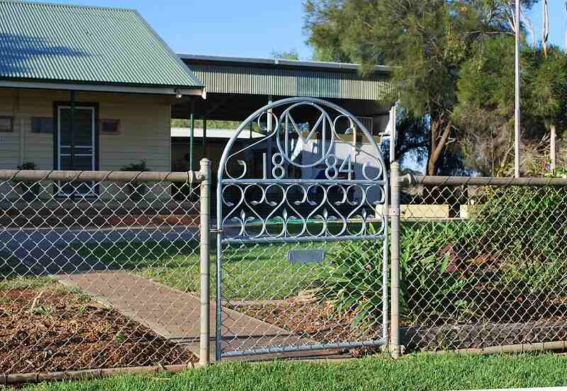 Chain link fence with gate in front of house