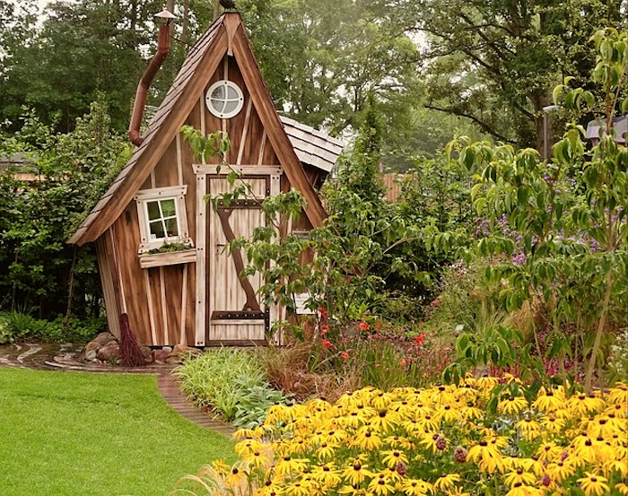 Brown garden shed near black-eyed Susans