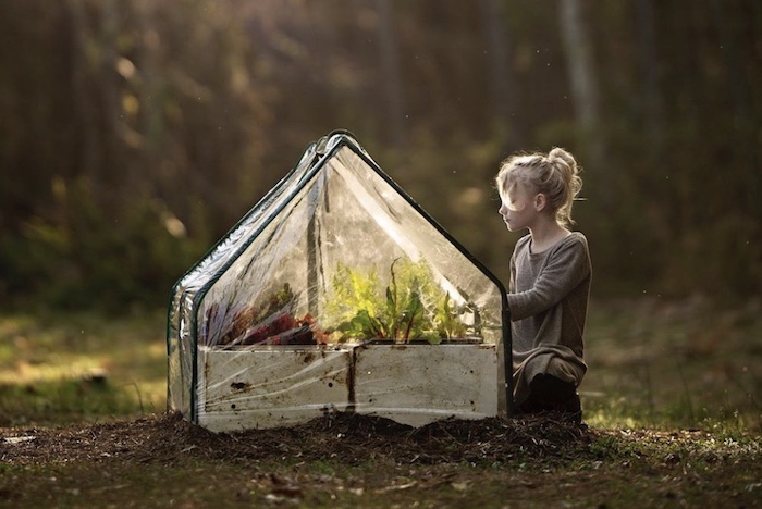 Young girl looking at raised garden beds