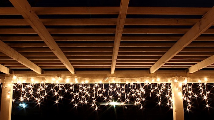 Small, twinkling string lights beneath wooden structure