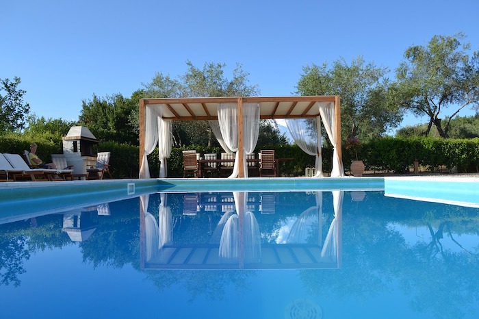 Pergola near pool with curtains