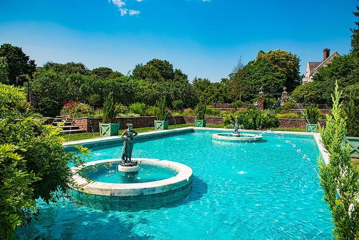 Blue swimming pool featuring water fountains