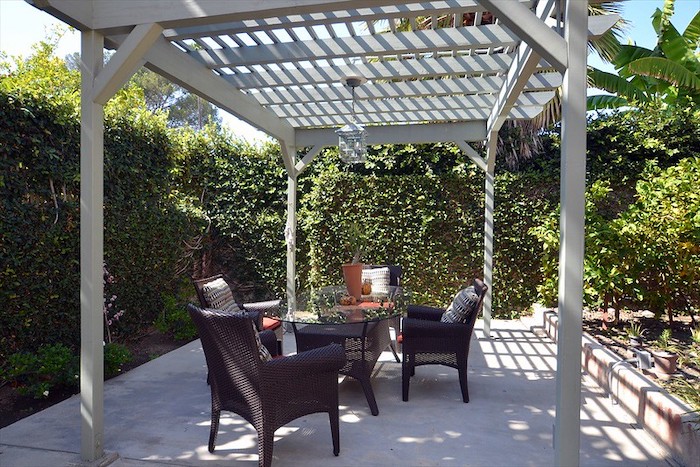 Outdoor seating area beneath a pergola with trellis roof 