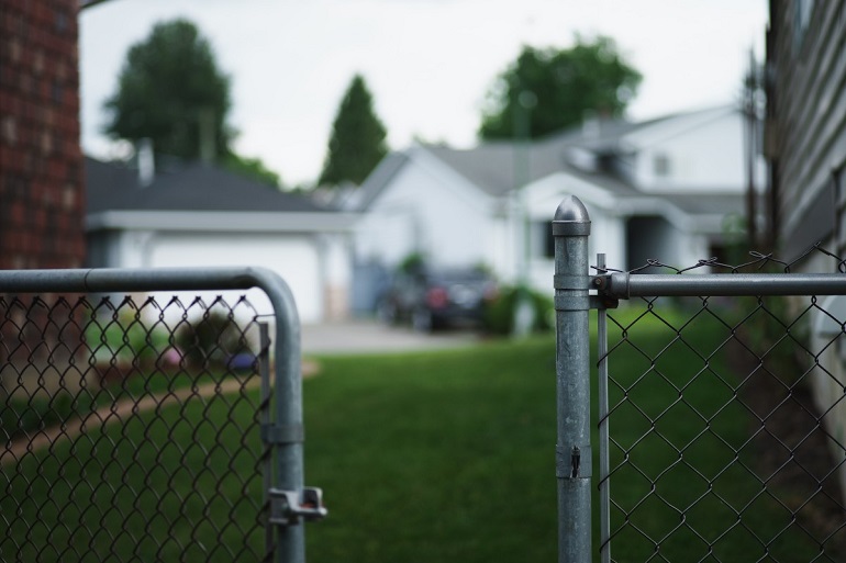 Close up image of open chain-link fence gate