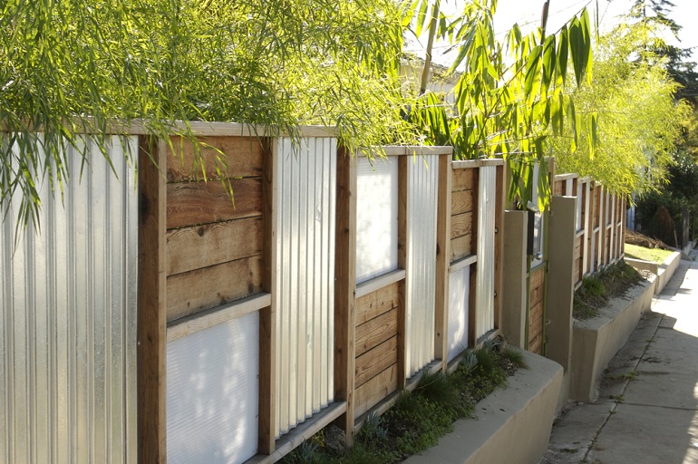 Fence with alternating panels of metal and wood