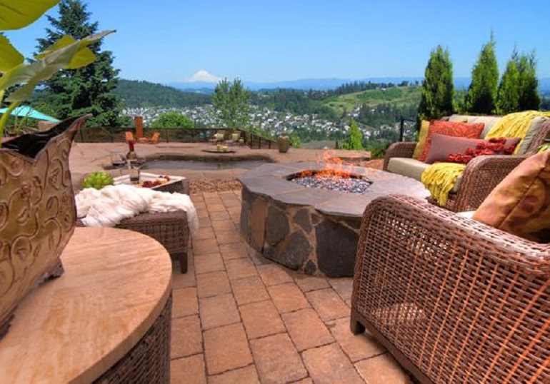 Patio with a fire pit in the middle surrounded by chairs