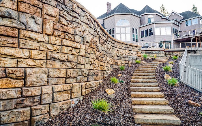 Large retaining wall made of landscaping blocks next to small stairway