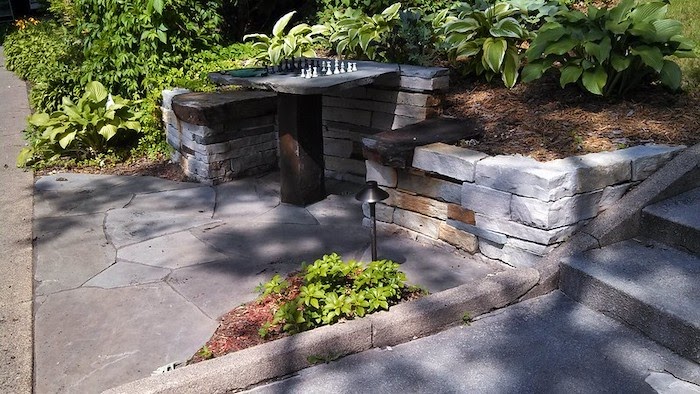 Small gray retaining wall next to a chess board