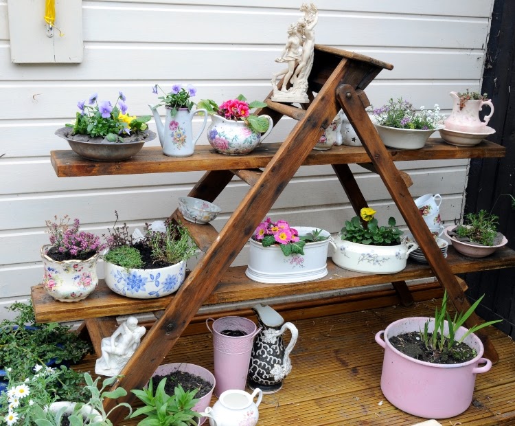 vertical gardening with a ladder featuring various pots of flowers