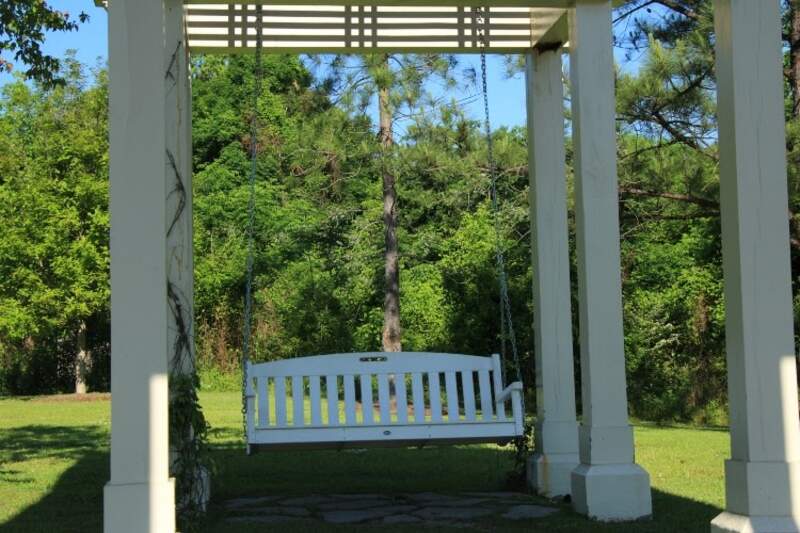 white, wooden pergola with swing