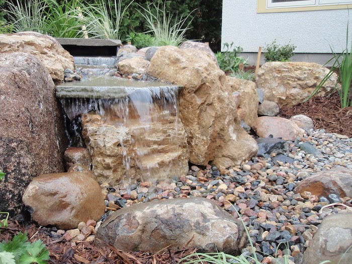 Water falls into a bed of small rocks