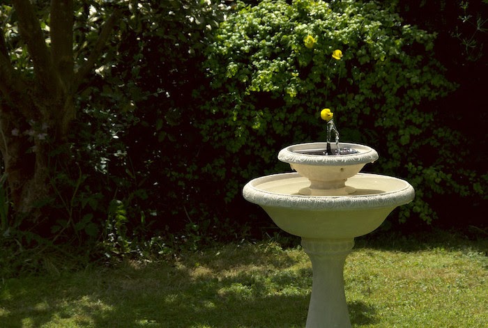 Contained water fountain against a lawn background