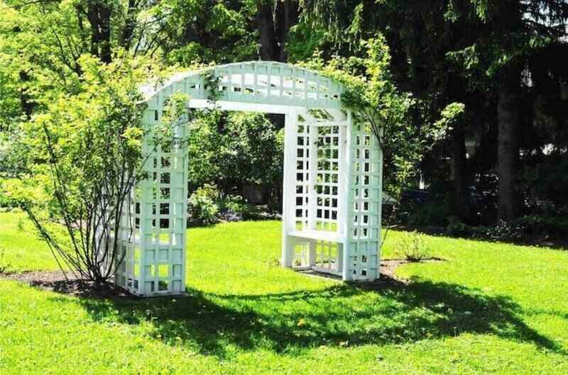 White arched trellis in the middle of the yard