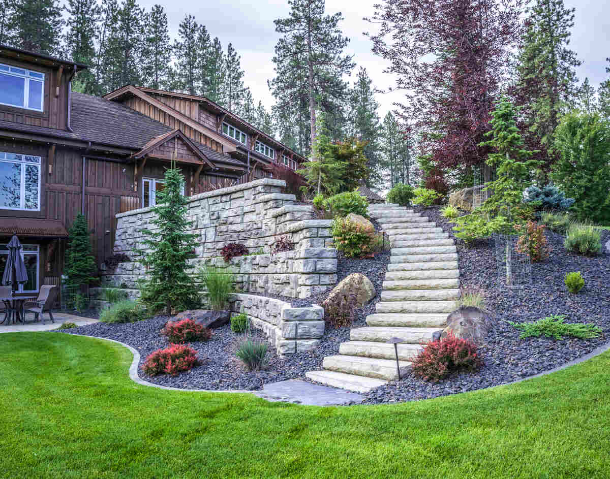 A retaining wall retains a set of stairs and several plants