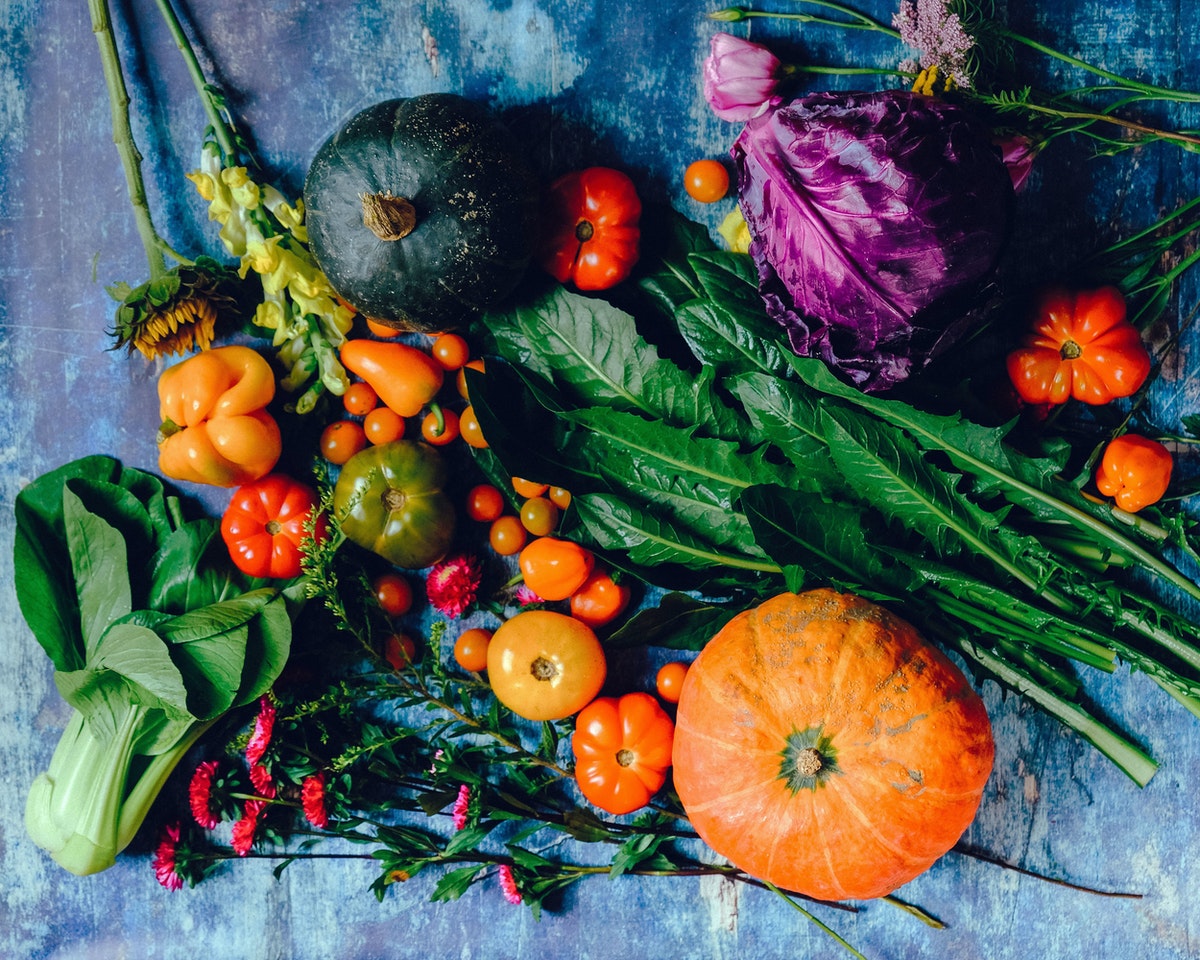 A flat lay of vegetables on a blue surface