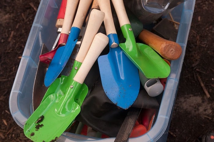 A box of bright colored garden trowels