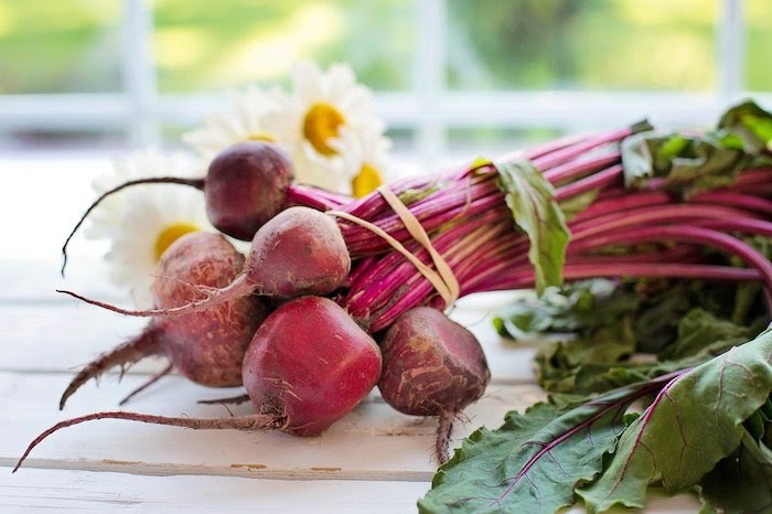 Close up of beets on a white wooden surface
