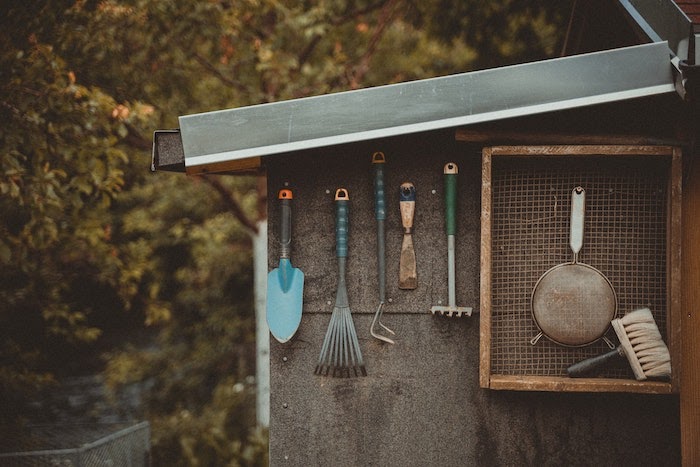 Garden tools hang on a wall