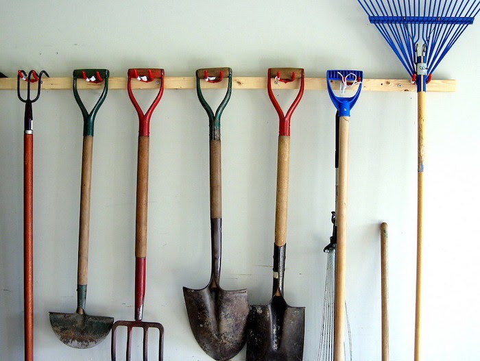 Garden tools hang on wall