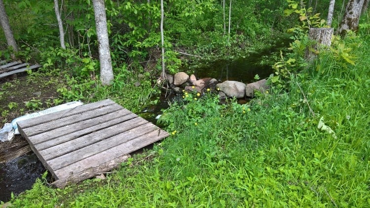 wooden pallet bridge over small creek