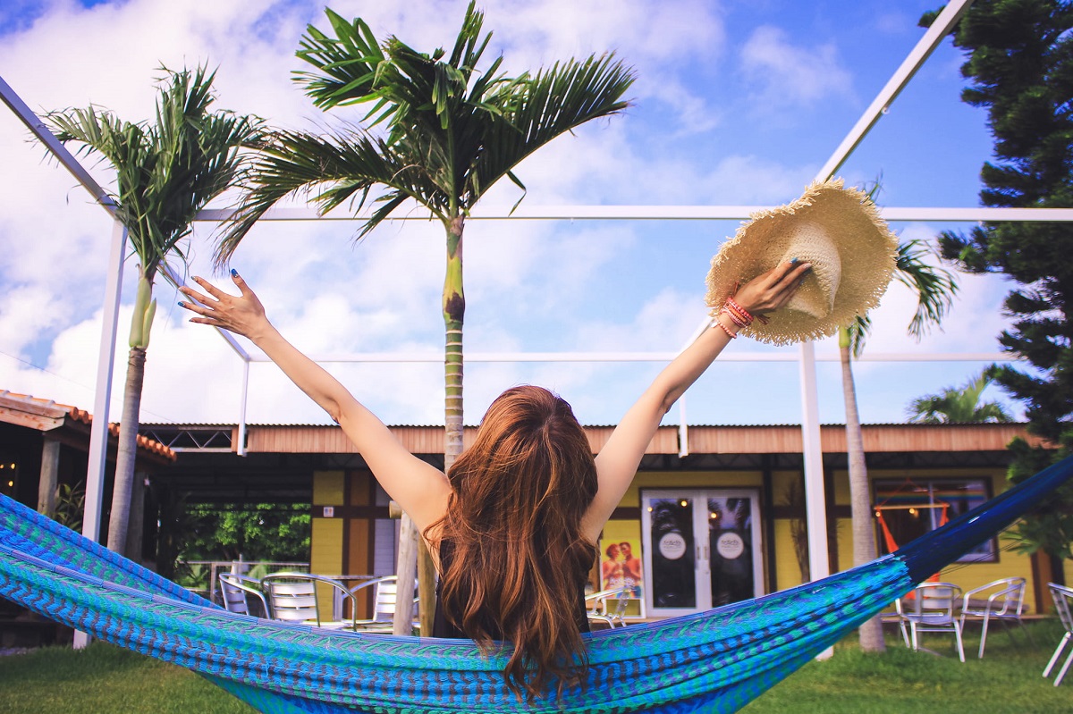 woman in hammock stretching with palm trees in background