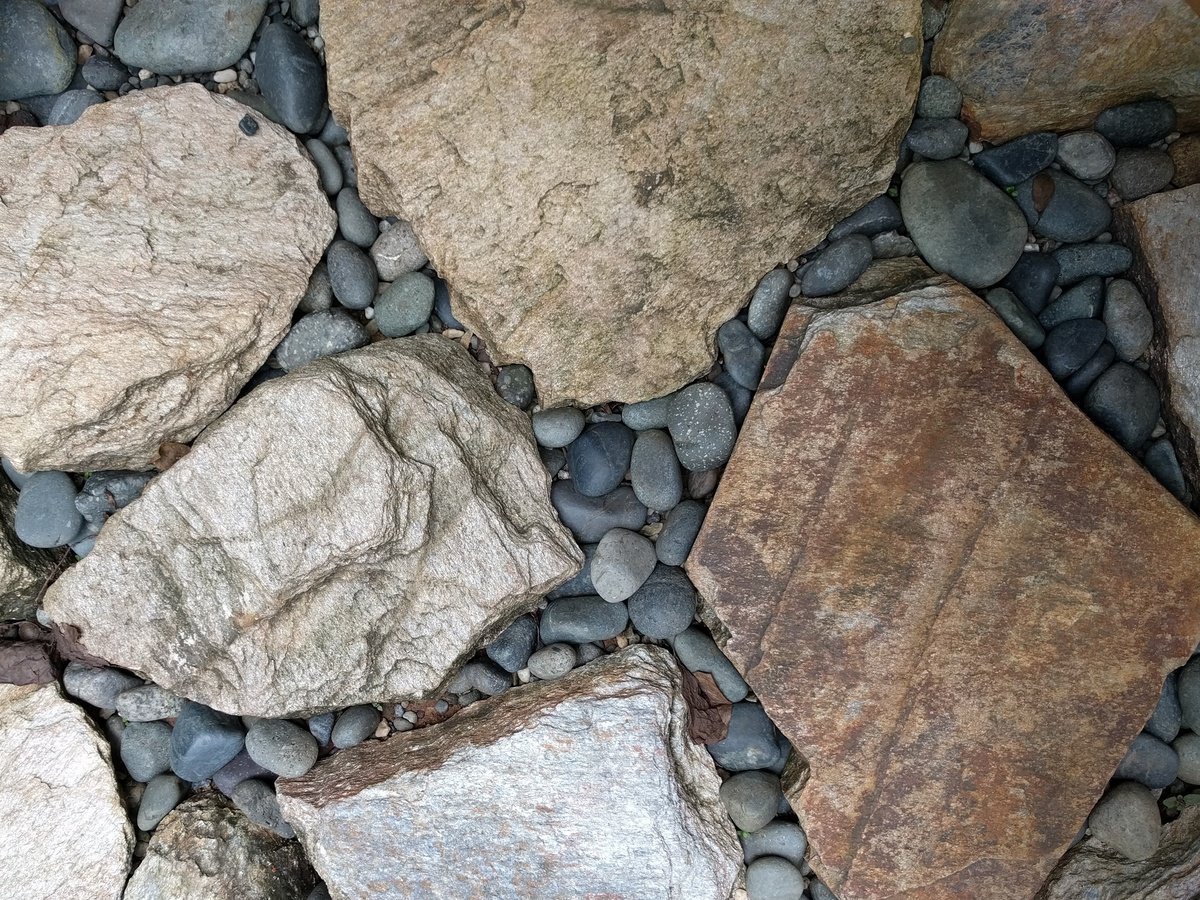 Flagstone patio with river rock filling in the gaps between the stones.