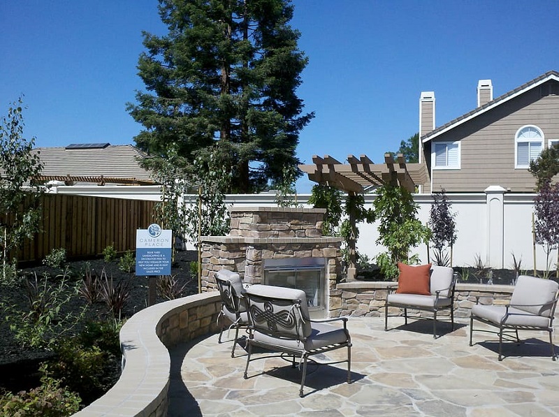 stone patio with fireplace and chairs