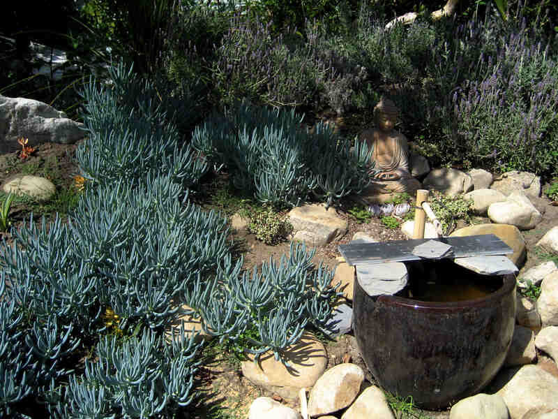 xeriscape garden with stones, statue, and water feature