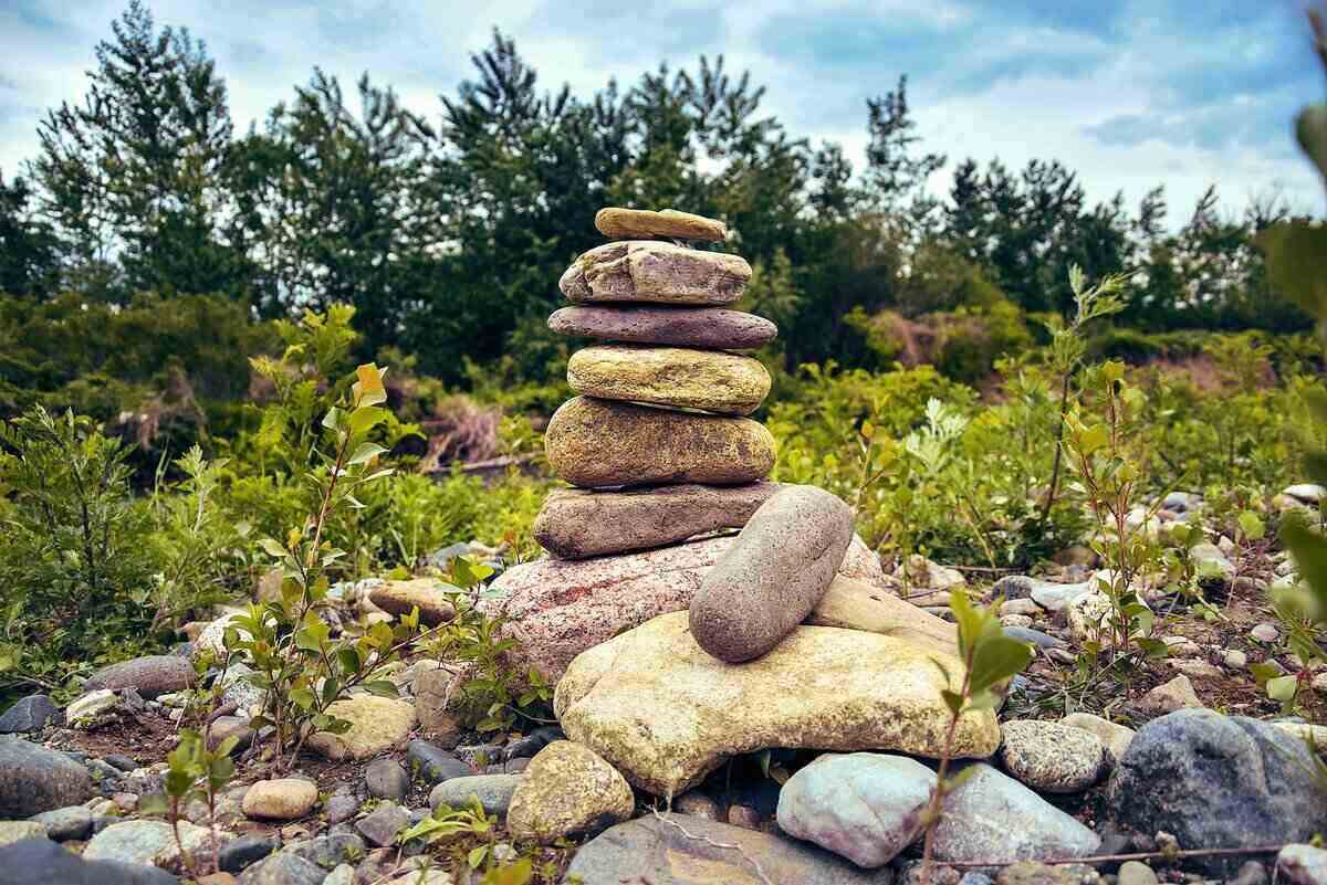 A stack of river rocks with trees in the background