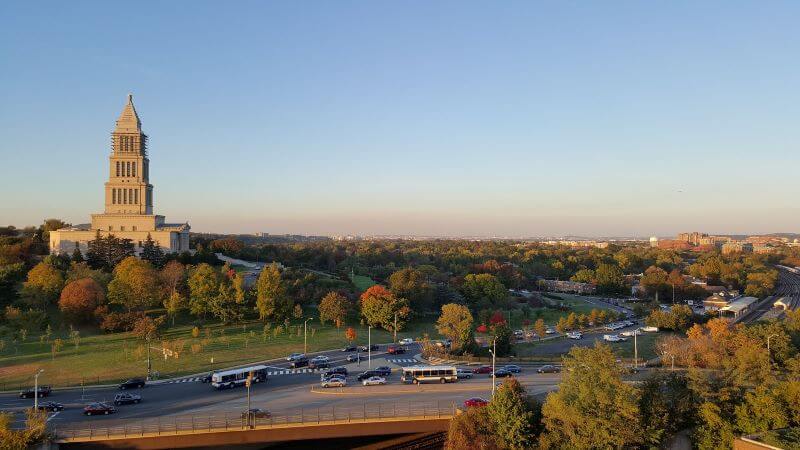 Colorful foliage surrounds a stately building in Alexandria during golden hour.