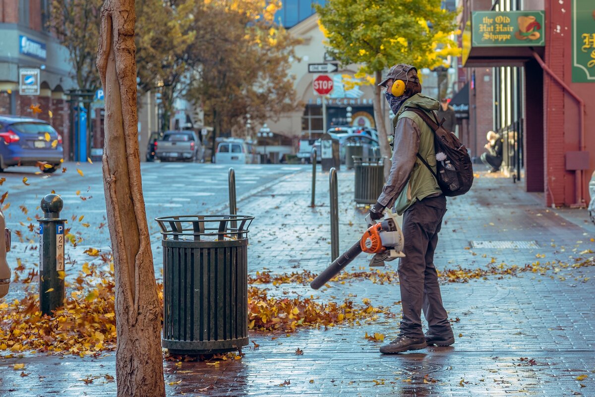 Man using cordless leaf blower on the sidewalk