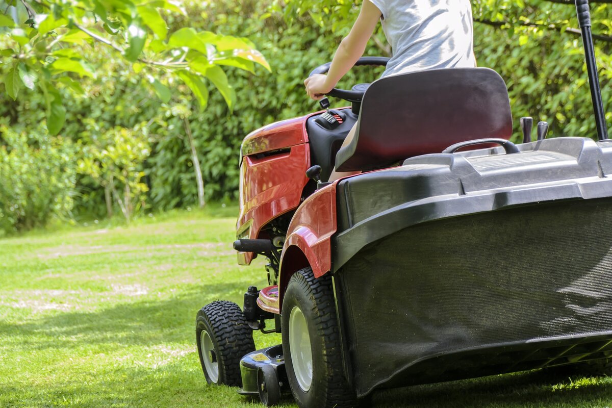 Man on an orange riding mower