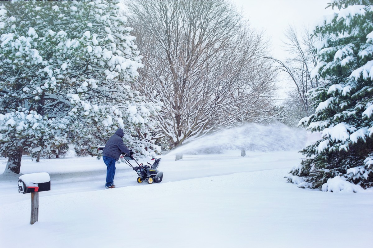 Man using snowblower to remove snow from driveway