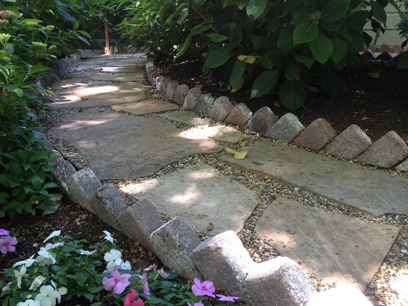 Stone walkway through flowers and greenery