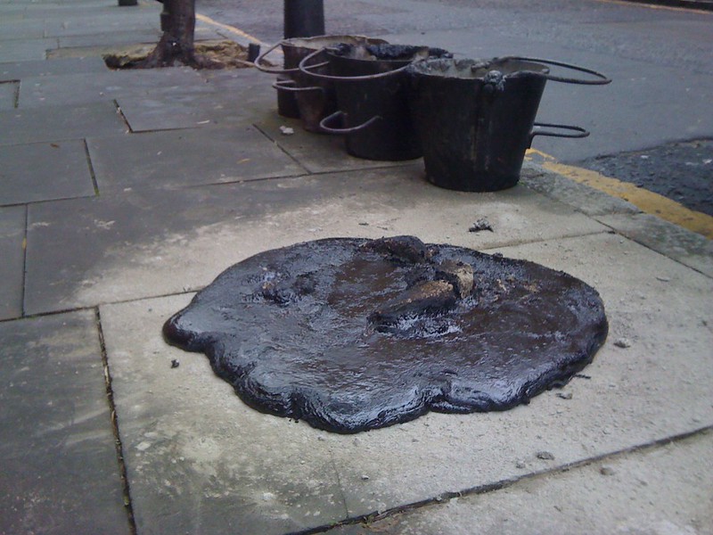 Pile of liquid asphalt/tar on a sidwalk