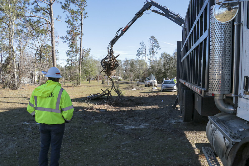 Large claw truck removing tree debris